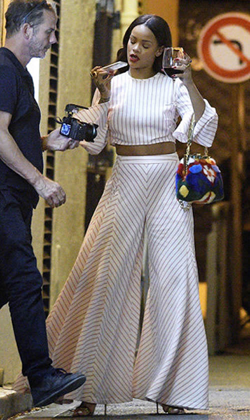 借酒消愁..在法国尼斯的Rihanna得知恐怖袭击后面无表情, 手端一杯葡萄酒走出餐厅 (照片)